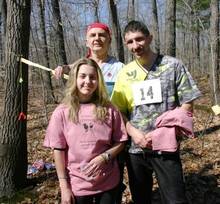 Three orienteers pose with t-shirts.
